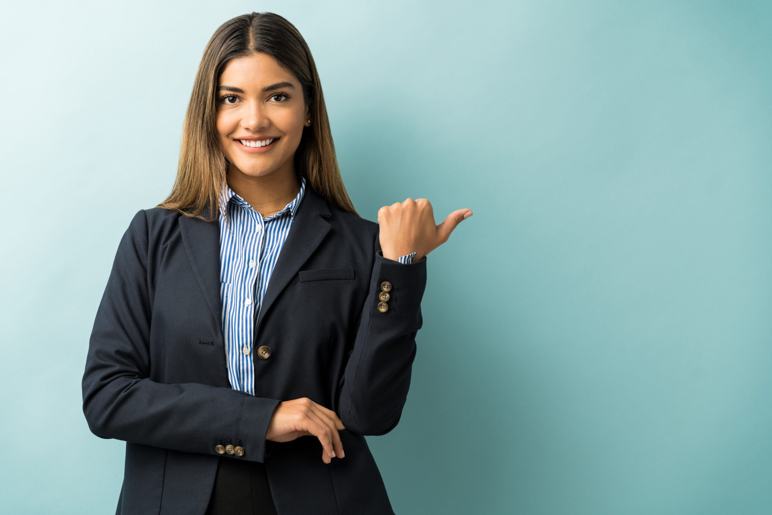 hispanic female executive gesturing copy space while making eye contact studio scaled
